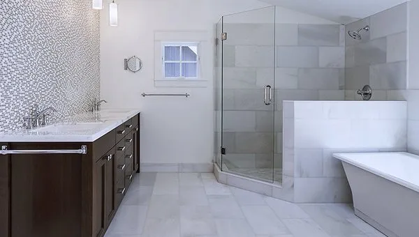 A bathroom with a large walk in shower and a sink.