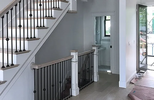 A hallway with stairs and a door way.